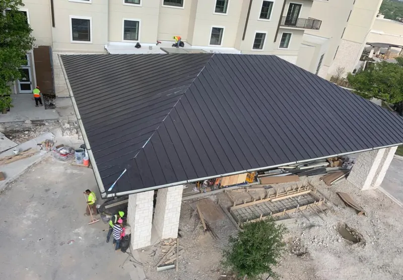 Metal roofing installation team working on a commercial building in Gas City